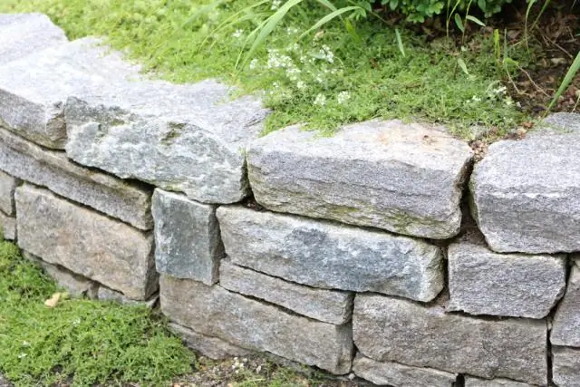 Wie baut man eine Steinmauer mit einem runden Stein?